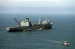 RoRo-Fahrzeugtransportschiff Altair 1986, beim Entladen von Gerät auf eine schwimmende Verladebrücke