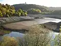 Urftstausee bei Niedrigwasser mit der ehemaligen NS-Ordensburg Vogelsang im Hintergrund