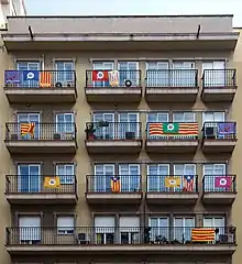 Foto eines Hauses mit ausgehängten Flaggen „Si“, der Senyera und der Estelada