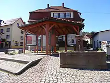 Zentraler Dorfplatz mit Brunnen