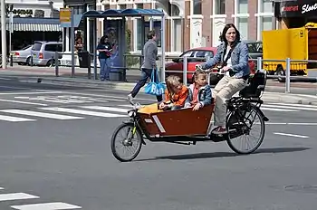 Den Haag (Nederlando) : patrino kun du infanoj en 'bakfiets' (kestobiciklo)