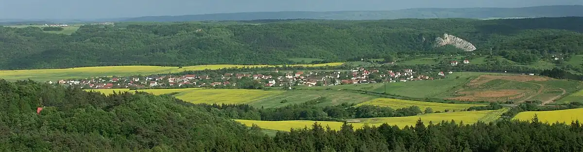 Vido al Vráž direkte de nordo al sudo, fotita el belvedero super municipo Lhotka u Berouna. En fomno elstaras roko Svatojánská skála, dominaĵo super municipo Svatý Jan pod Skalou