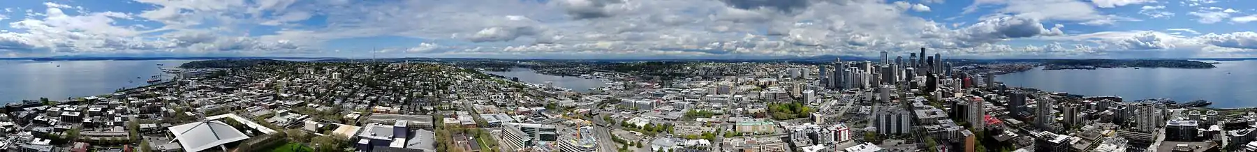 Panorama vido de sur Space Needle: preskaŭ 360-grada vido inkluzivanta (de maldesktre) Puĝetan Fjordon, Monteton Queen Anne, Lagon Unian, Monteton Kapitolan, la Seatlan urbomezon, Golfeton Elliott, kaj Okcidentan Seatlon.