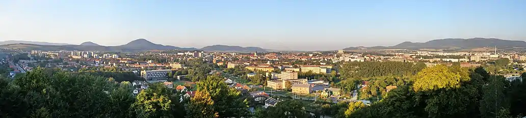 Panoramo de Prešov el monteto nomata Kalvario. Maldekstre montetaro Šarišská vrchovina kun monteto Šarišský vrch kaj Burgo de Šariš, meze centro kaj turo de sankta Nikolao, malantaŭ ĝi estas malforte videbla burgo Kapušanský hrad, dekstre antaŭe areoj de Universitato de Prešov, loĝdomaro Sekčov kaj Slanské vrchy.