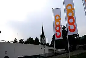 Rigardo de la parkloko de Coop-supermerkato en la centro de Wangen ĉe Olten al la preĝejo