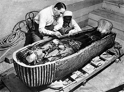 Howard Carter egiptologoa Tutankhamonen sarkofagoa eta momiaren aurrean.