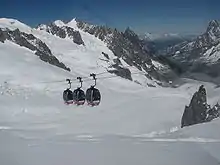 Três cabines de la Tèlècabina Panoramica Mont-Blanc sus la Valâye bllanca qu’est un gllaciér dedens lo massis du Mont Blanc