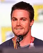 Stephen Amell jwe kòm Oliver Queen / Green Arrow.