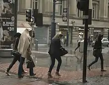 Women rushing to get out of the rain.